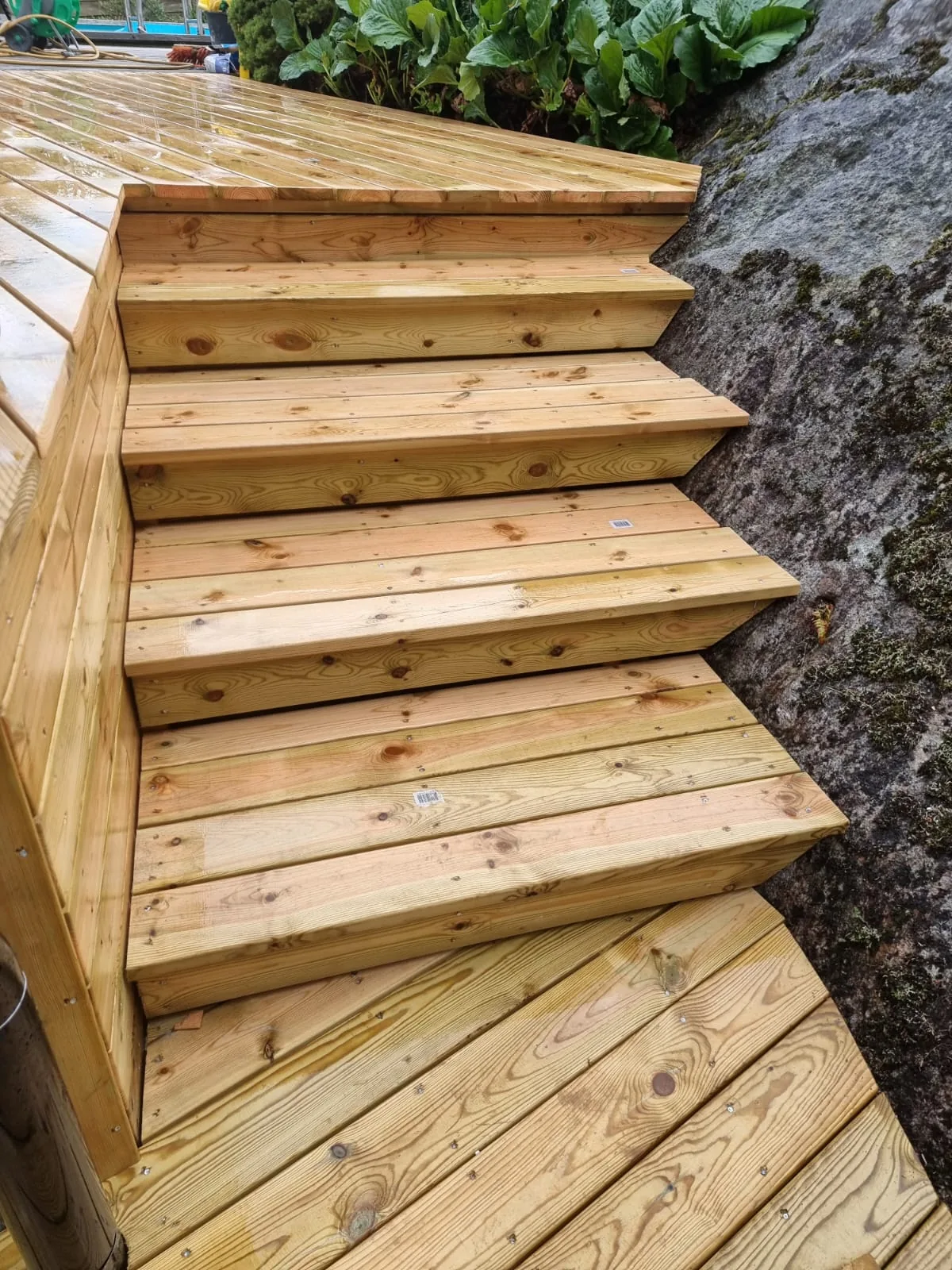 Detalj av trästeg och trallkanter som är anpassade till berget i Grödby.